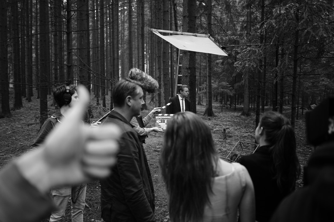 Behind-the-scenes photo of the crew rigging a light and camera at night