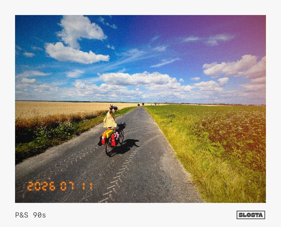 A cyclist riding down a country road through a golden field