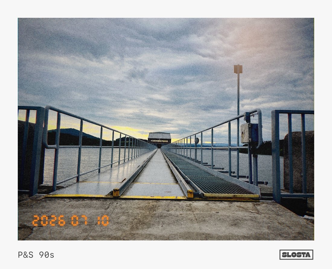 A bridge railing stretching toward the horizon at dusk