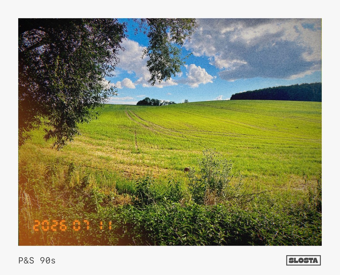 A green field under a blue sky with scattered clouds