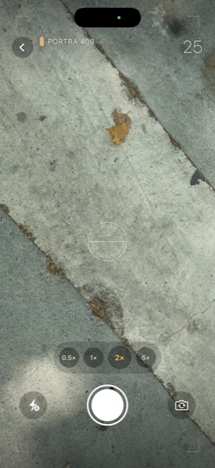 SLOSTA viewfinder on a Portra 400 roll — a live scene of pavement and a fallen leaf, with a frame counter, level, zoom options and a large shutter button, and no preview of past shots